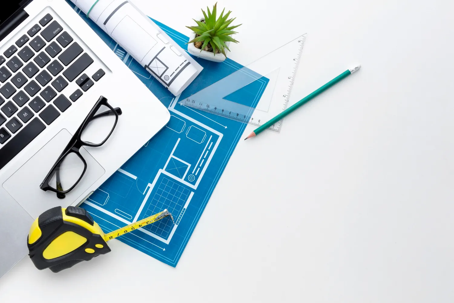 Tavolo di lavoro con progetto, metro e strumenti da disegno